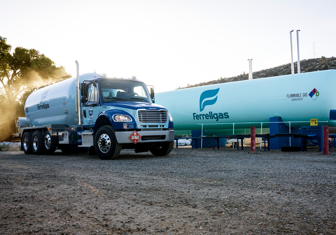 Ferrellgas delivery truck parked near a large, bulk-storage propane tank.