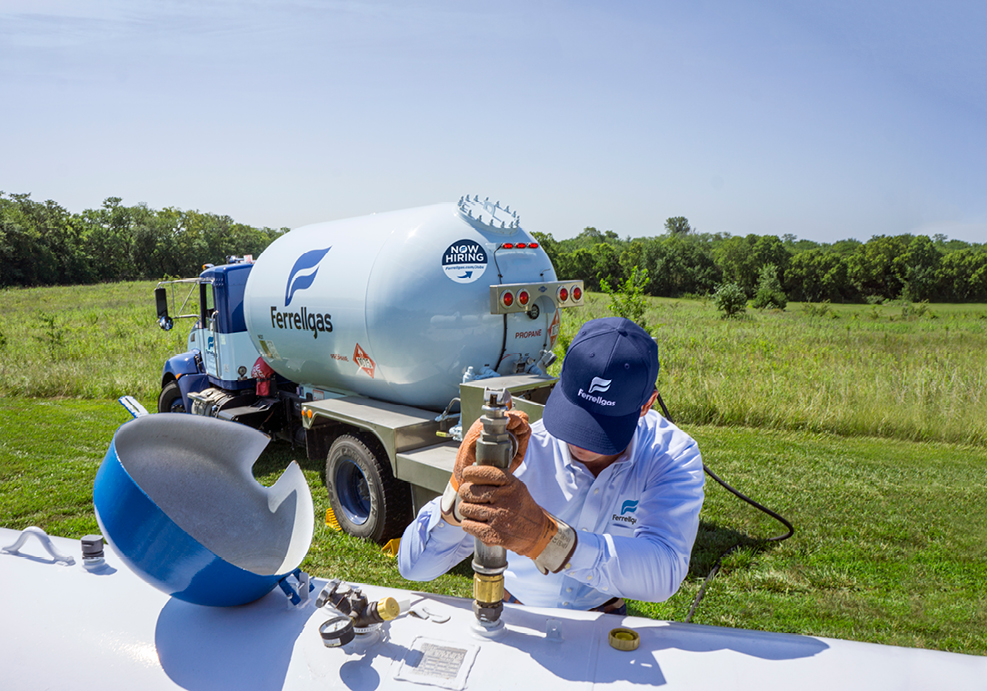 A Ferrellgas Delivery Driver filling a rural residential propane tank.