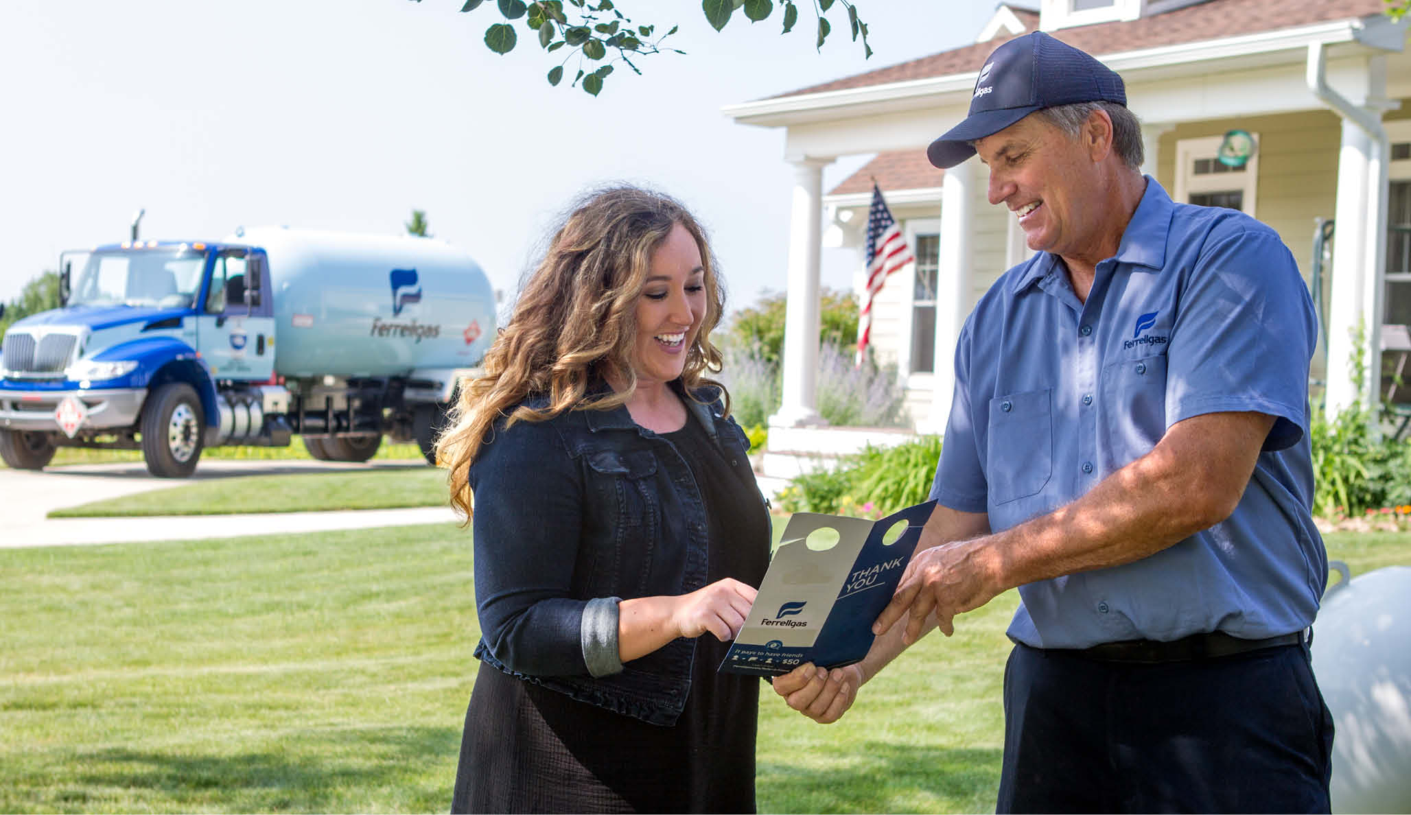 Ferrellgas Delivery Driver and customer talking and smiling in front of a home. 